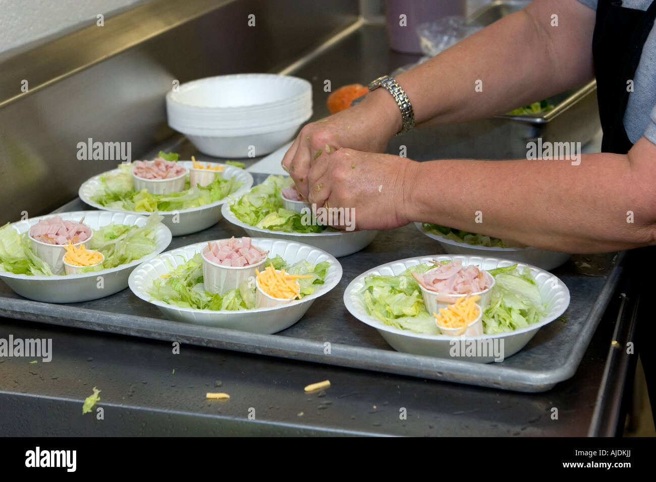 Il personale della cucina prepara insalate a pranzo giornalmente nella scuola di cucina Foto Stock