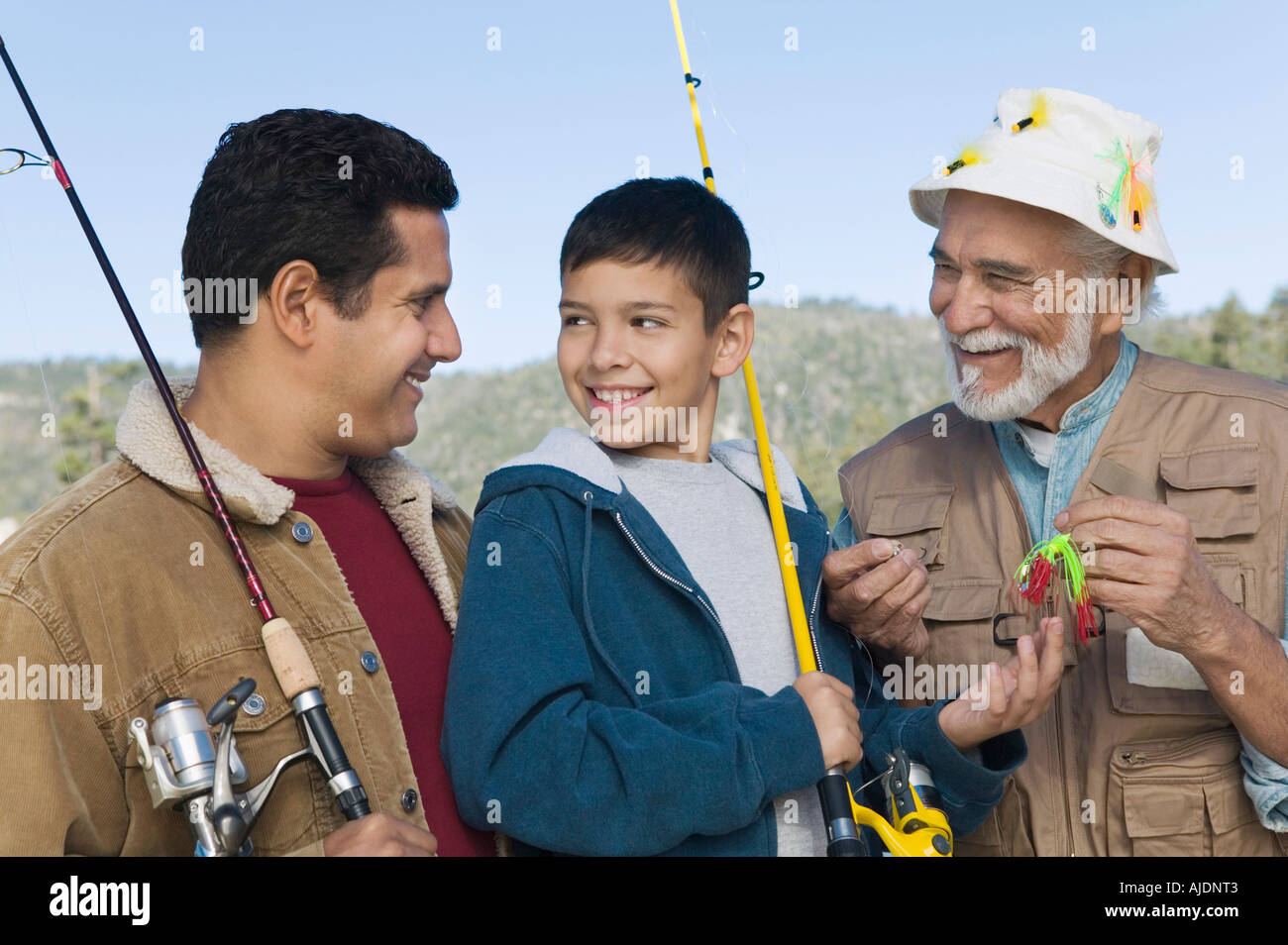 Elementi maschio di tre generazioni la famiglia sul viaggio di pesca, sorridente Foto Stock