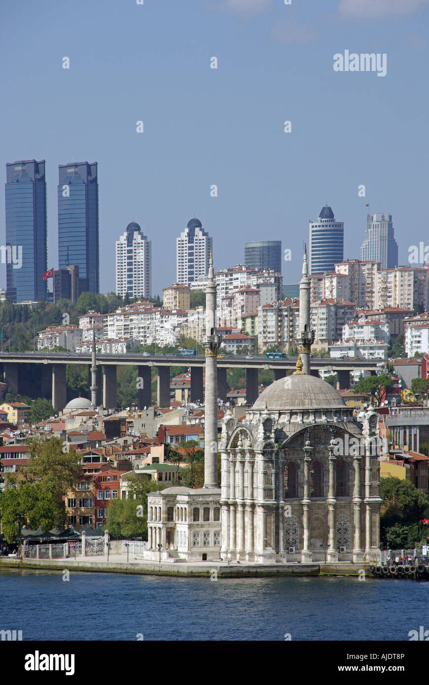 Istanbul Moschea Ortakoy accanto al Bosforo con edifici alti su di una collina al di là Foto Stock