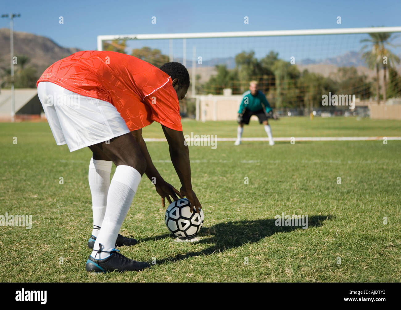 Giocatore di calcio la preparazione per il calcio di rigore, vista posteriore Foto Stock