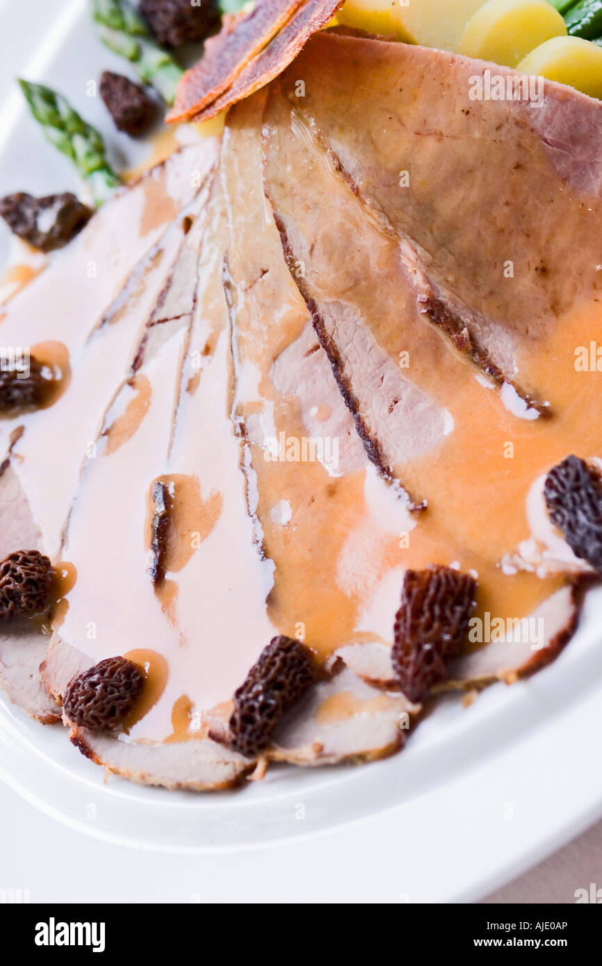 Fette di carne con salsa gravy e asparagi su piastra Foto Stock