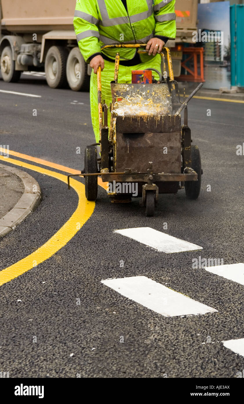 Segnaletica stradale, banda stradale, ingegneria, salute e sicurezza, verniciatura stradale, Uomini al lavoro, vernice trolly, linea di marcatura PRAM, linea di marciapiede successiva, segno giallo Foto Stock