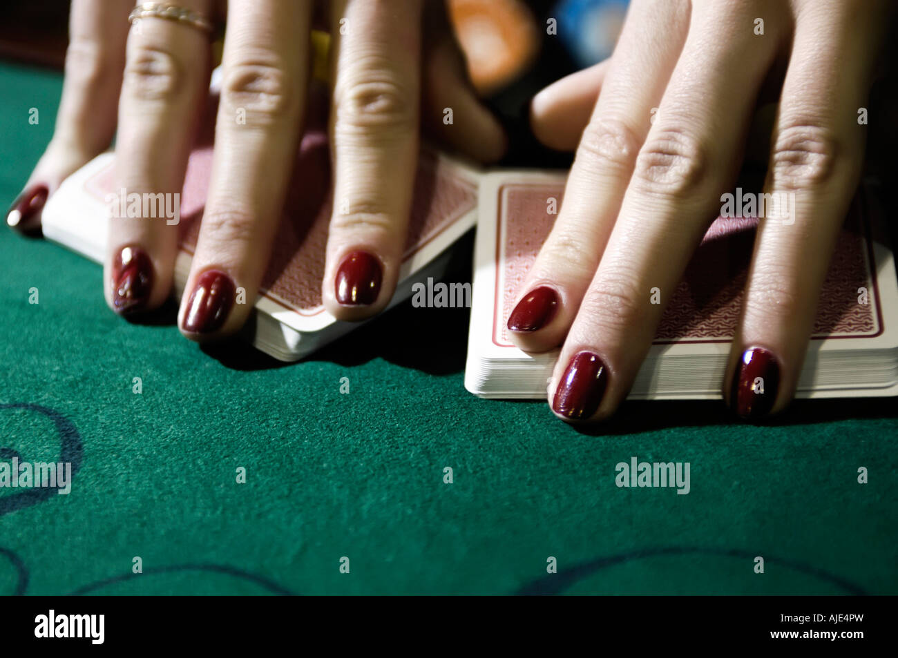 Le mani della donna croupier dealer rimescolare le carte Foto Stock