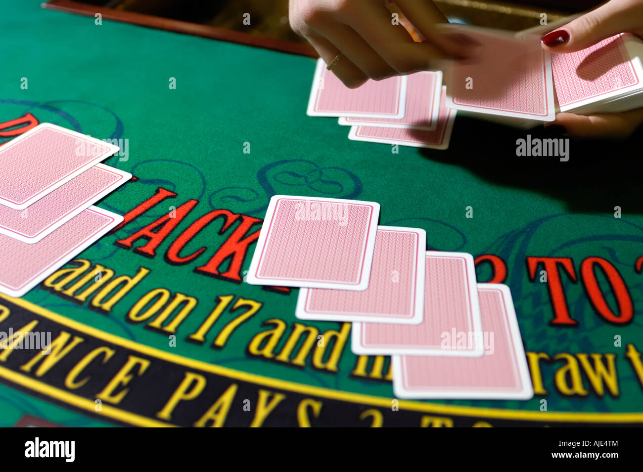 Le mani di una donna croupier che trattano le schede Foto Stock