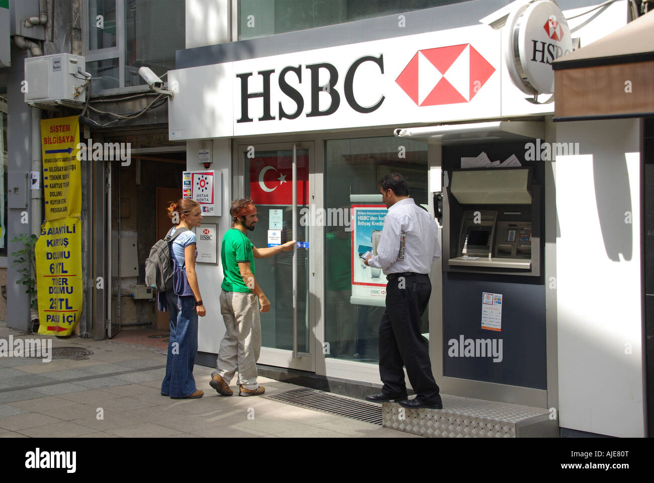 Istanbul i clienti al di fuori di HSBC Bank branch locali include il foro della parete bancomat Foto Stock