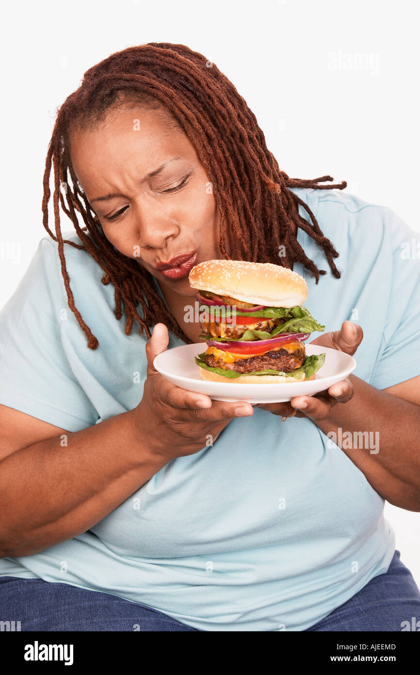 Donna sovrappeso holding hamburger Foto Stock