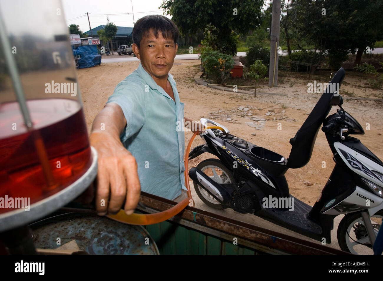 Attendant riempie il ciclo del motore dalla gravità erogatore di carburante Khao Lak Thailandia Foto Stock