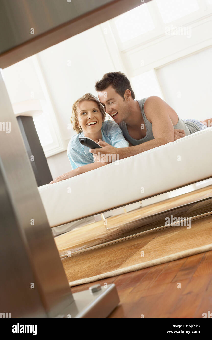 Giovane sul letto a guardare la televisione insieme Foto Stock