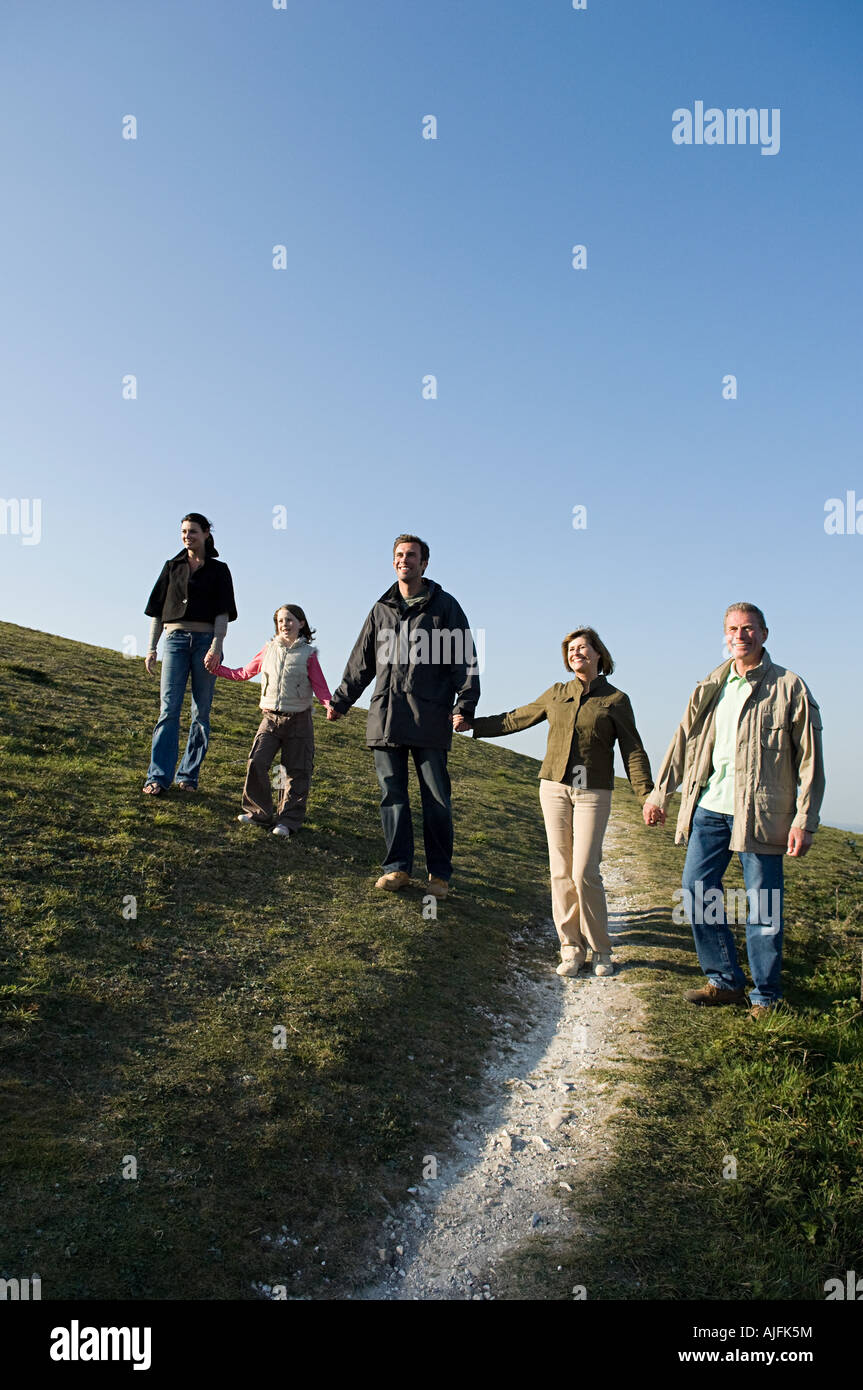 Famiglia camminando mano nella mano sulla collina Foto Stock