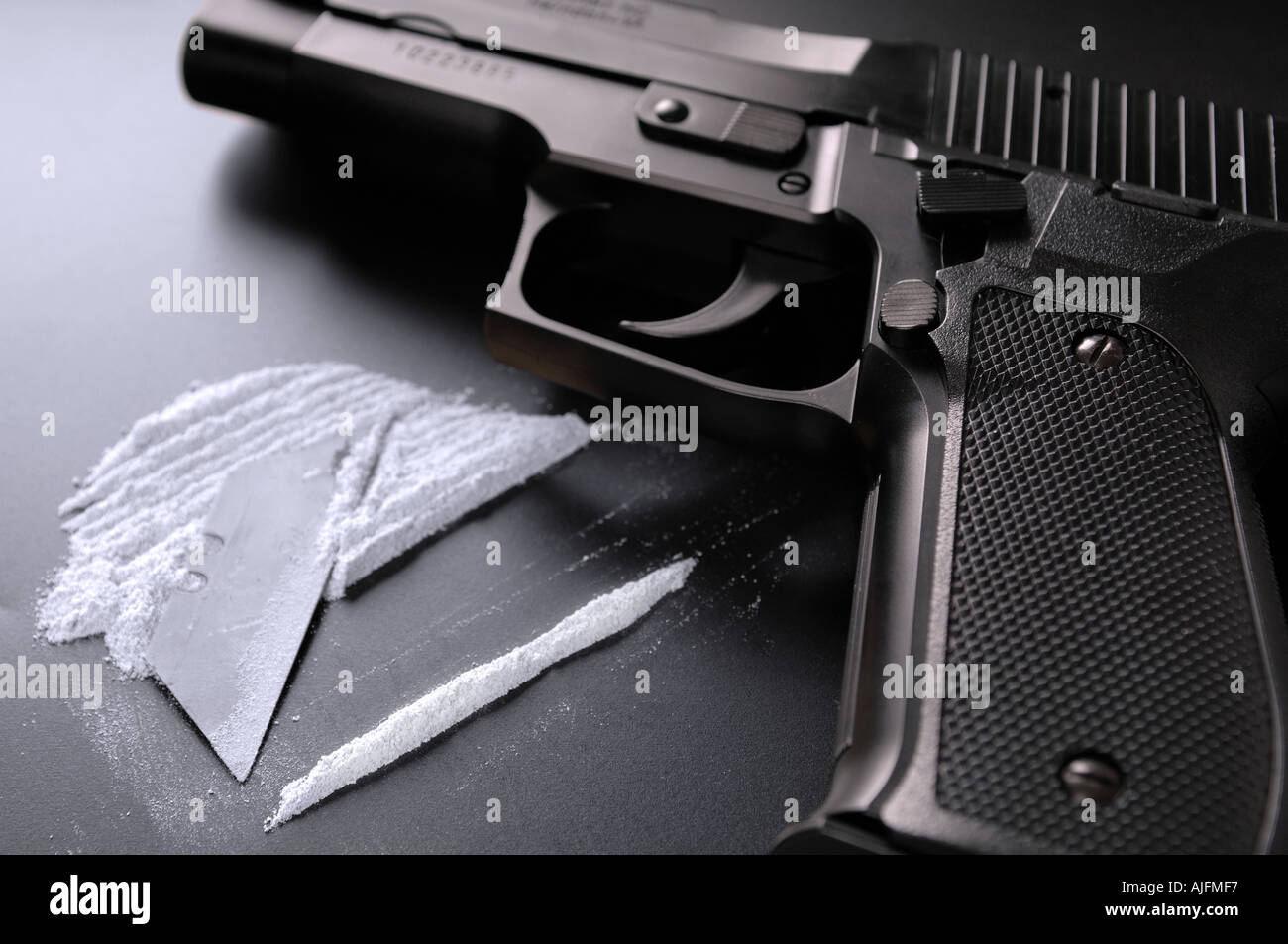 Una linea di cocaina e una pistola (replica pistola) Foto Stock