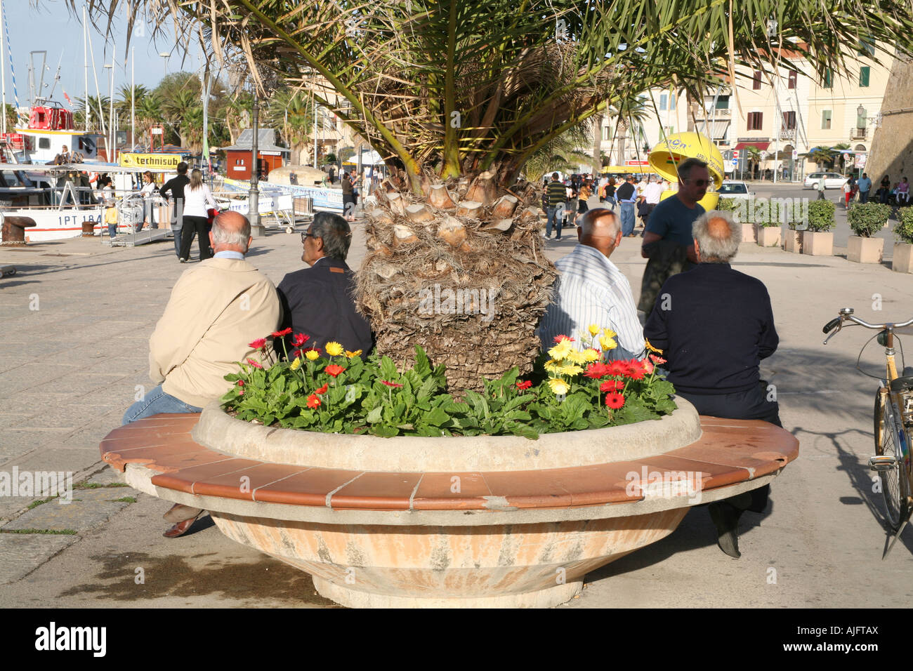 Anziani italiani rilassante la sera presso il porto di Alghero, Sardegna Foto Stock