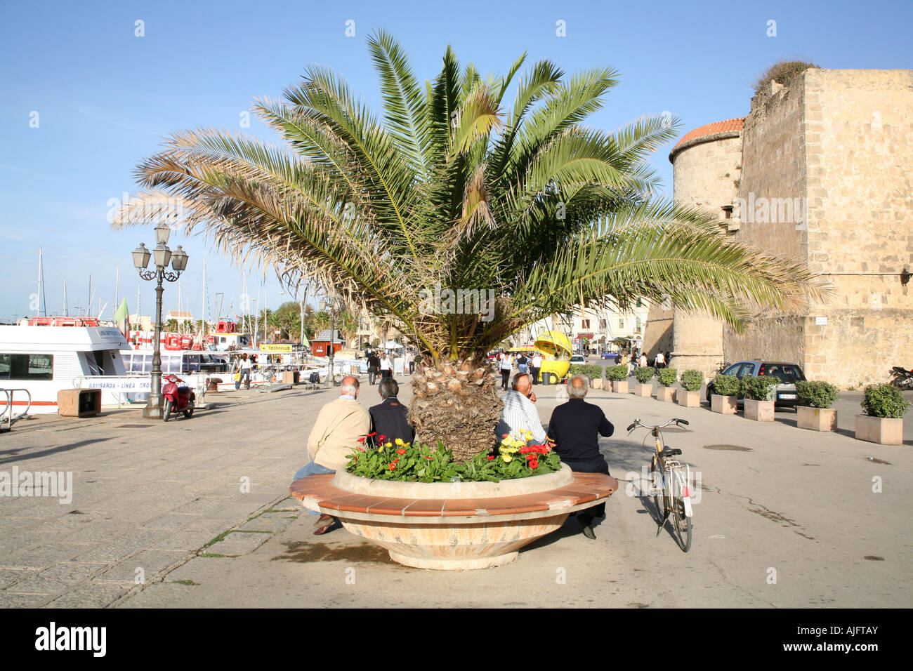 Anziani italiani rilassante la sera presso il porto di Alghero, Sardegna Foto Stock