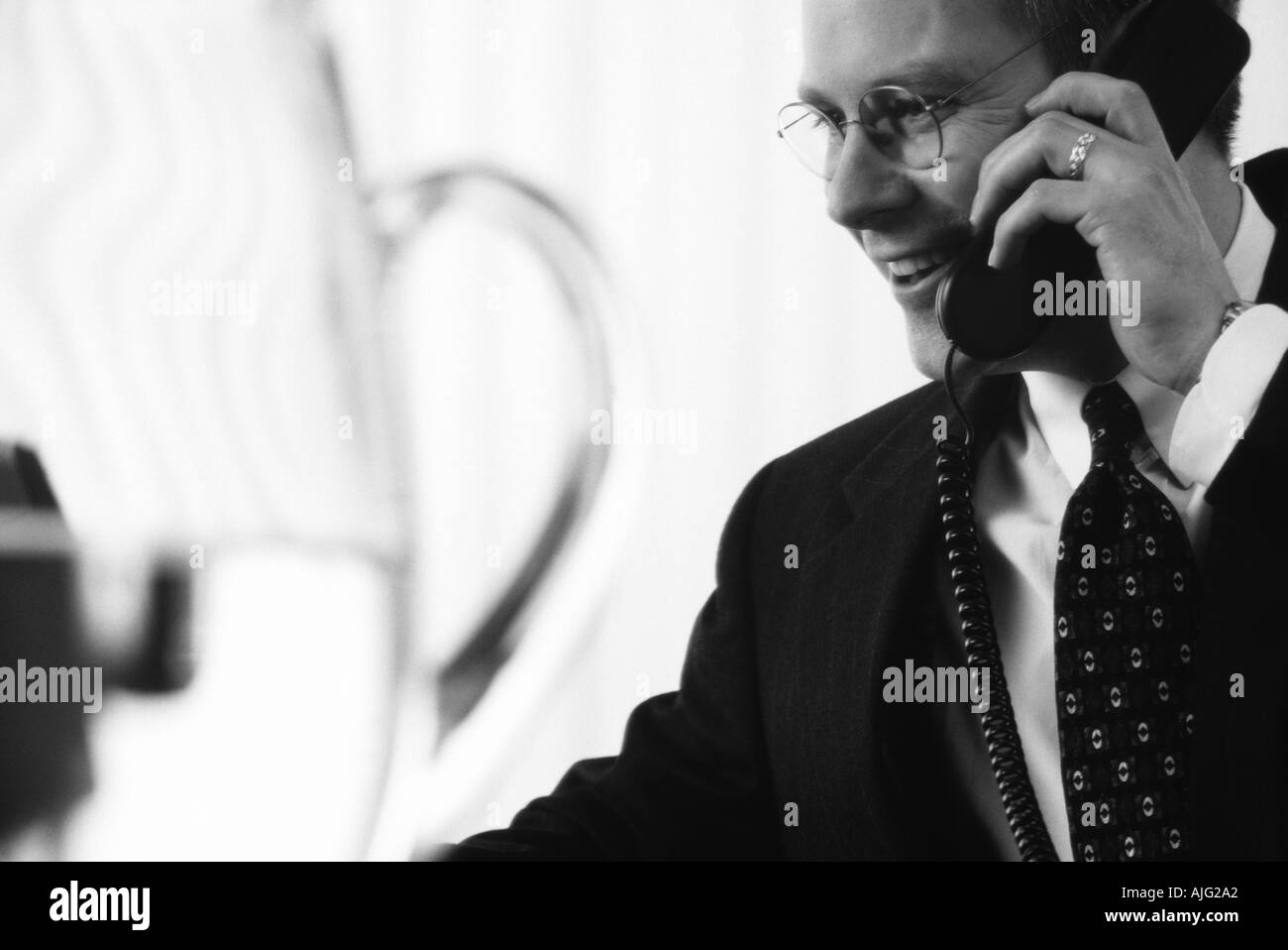 Foto in bianco e nero di un imprenditore caucasico parlando al telefono in sala conferenze Foto Stock
