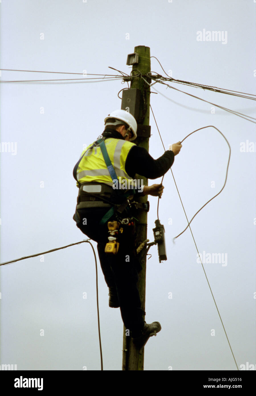 British Telecom cavo telefonico ingegnere di lavoro su un pilone per la riparazione di una riga difettosa Foto Stock