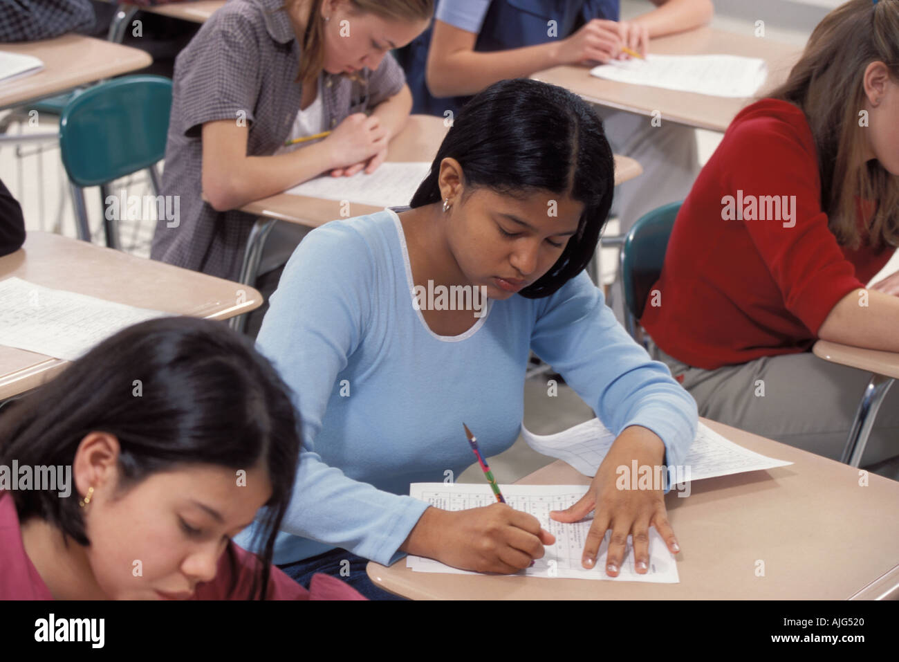 Indian-American female student concentrating and taking test in high school class Foto Stock