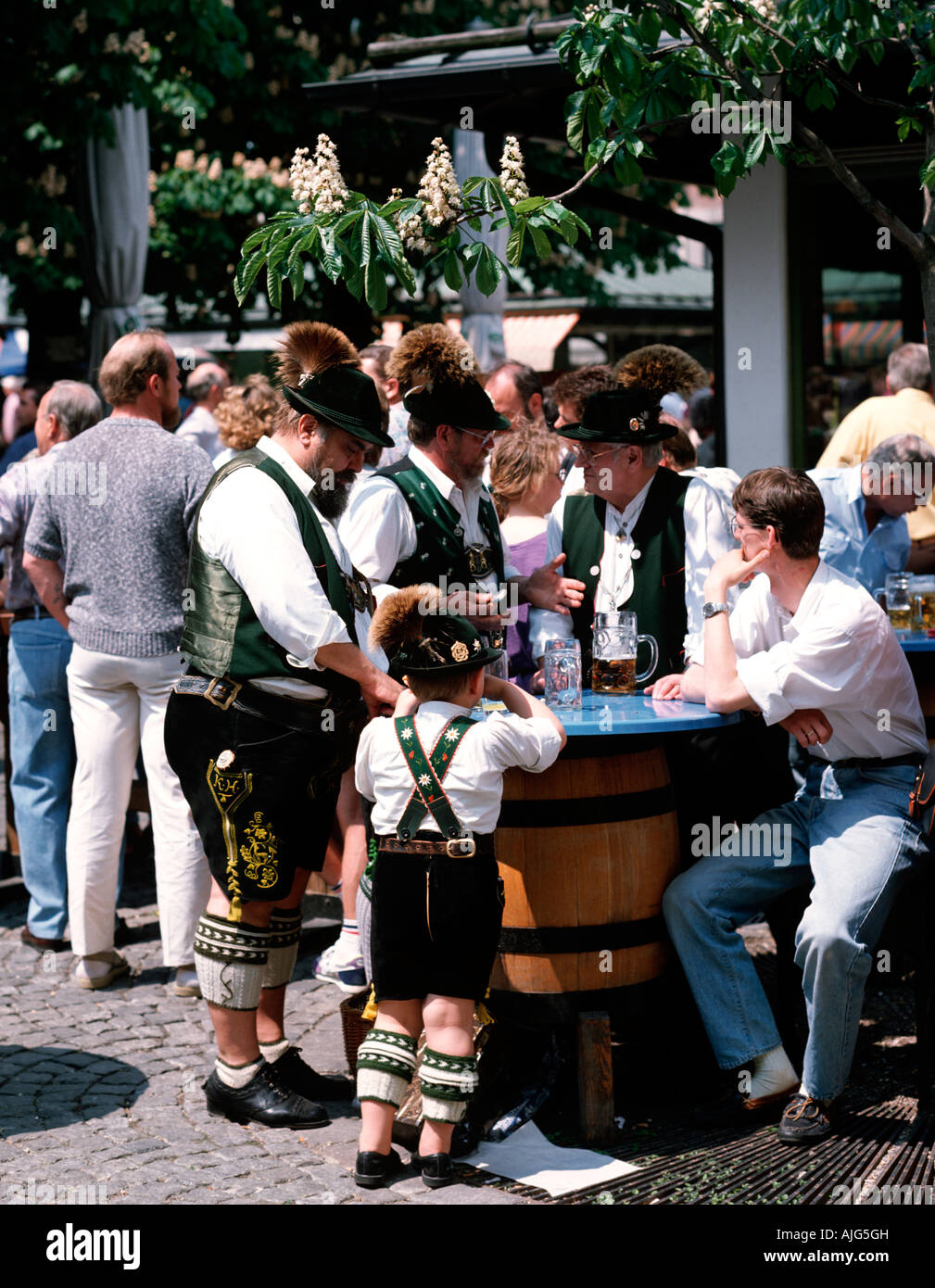 EU DE Germania Baviera Monaco di Baviera 3 uomini bavarese con un po' di sole a bere birra sul Viktualienmarkt Foto Stock