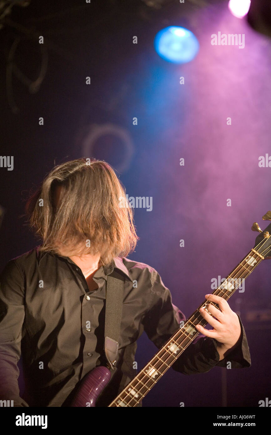 Giovane uomo suonare chitarra basso sul palco Foto Stock