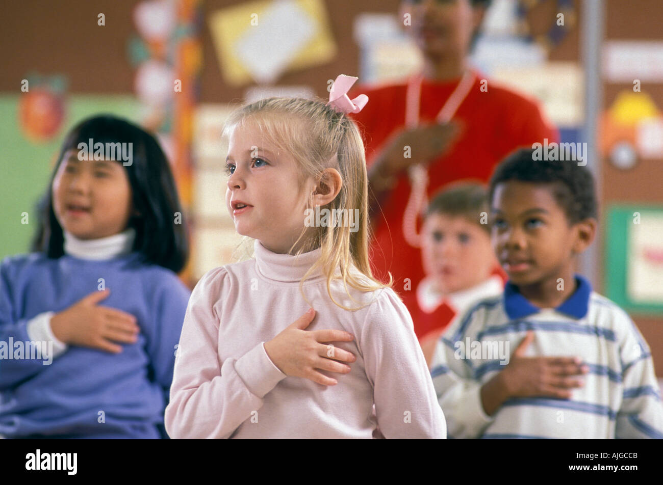 Gli studenti in età prescolare nella classe pledging fedeltà a bandiera Foto Stock