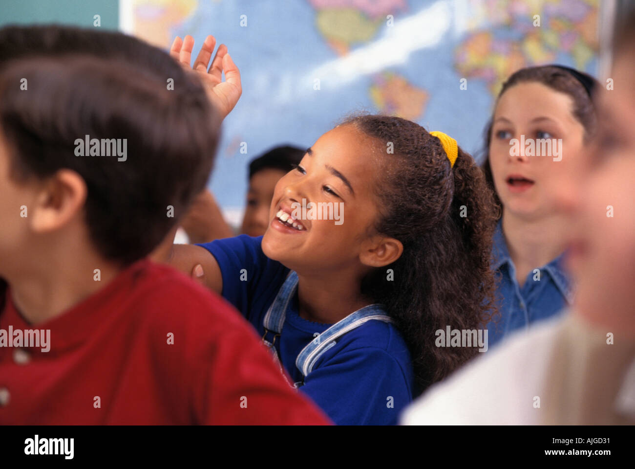 African American studentessa alzando la mano in classe Foto Stock