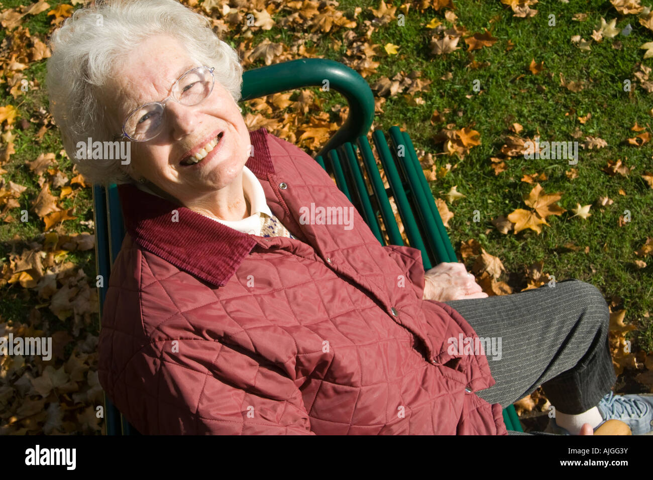 Anziana signora seduta su un sedile e guardare-up Foto Stock