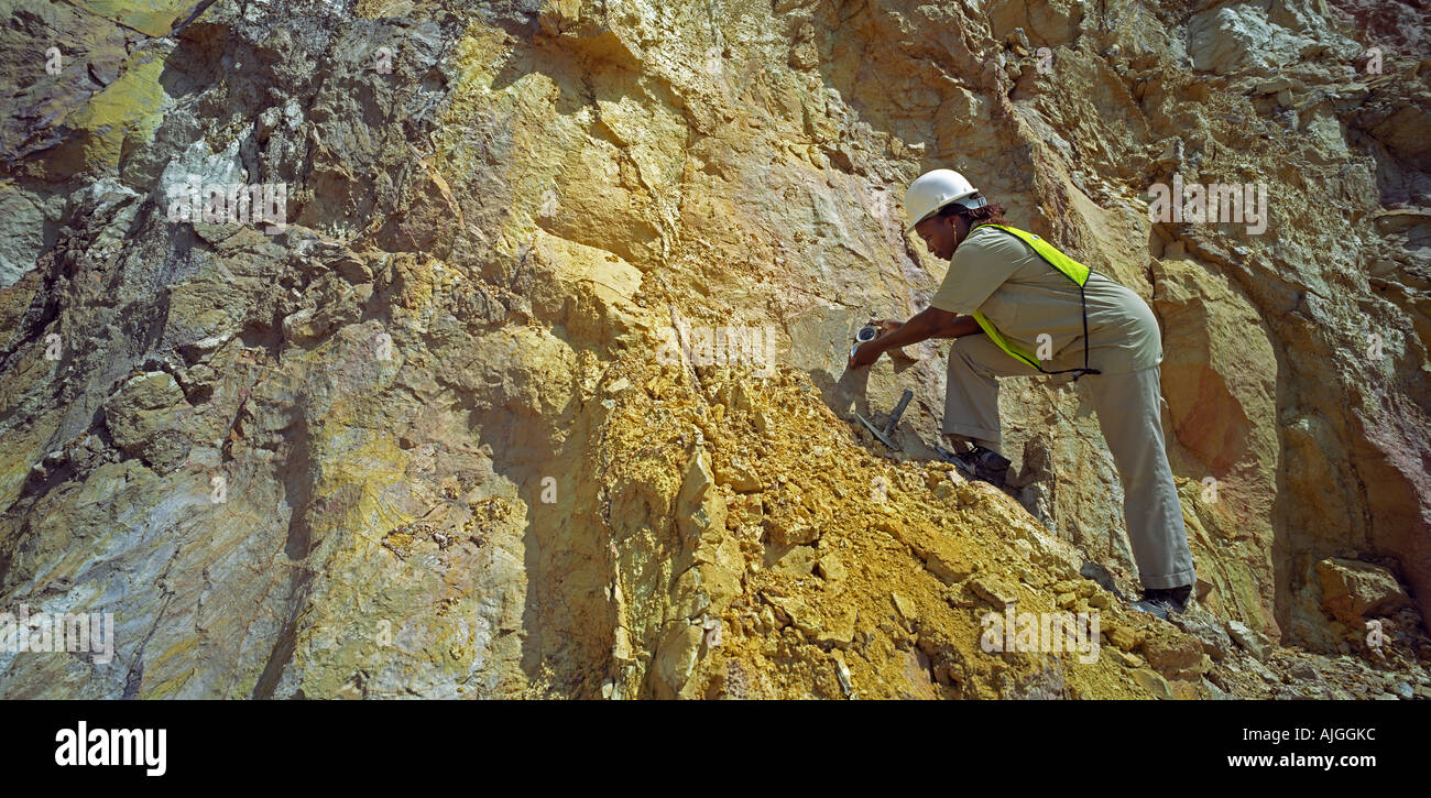 Donna del geologo esaminando roccia sulla miniera d'oro, Guinea, Africa occidentale Foto Stock