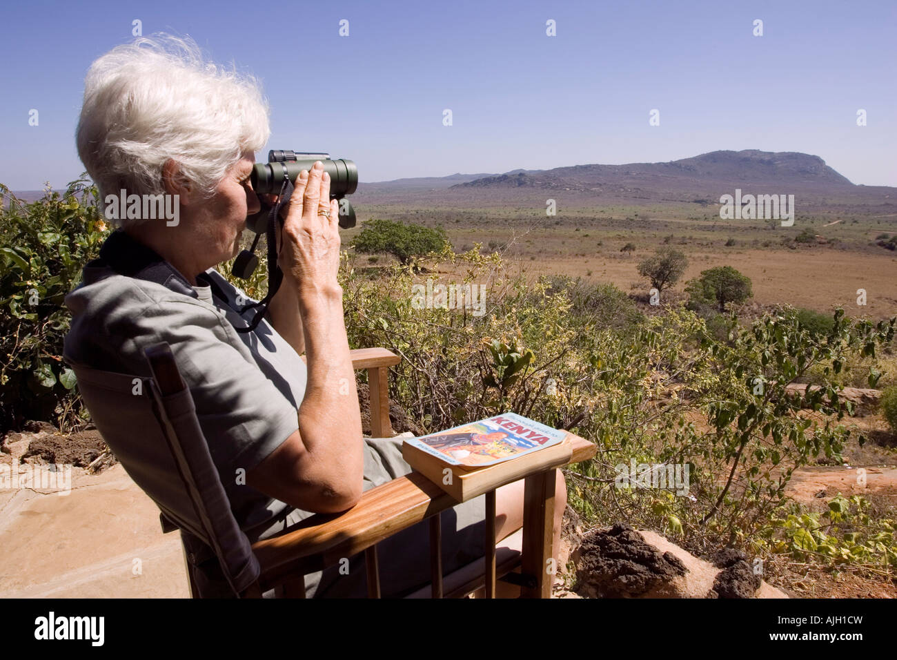 Tourist bird watching dalla veranda al Ngulia Bandas in Parco Nazionale Tsavo ovest del Kenya Africa orientale Foto Stock