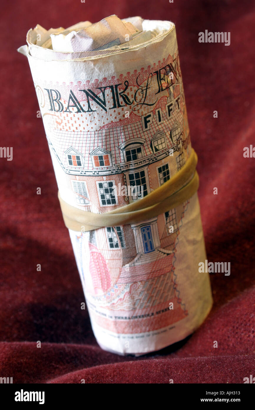 Rotolo di cinquanta pound note tenute con banda elastica Foto Stock