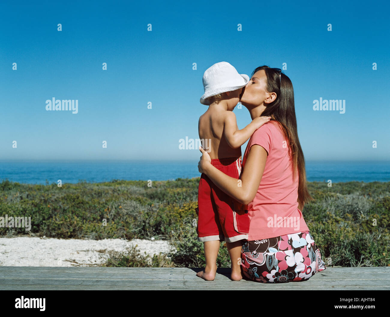 Madre baciare il suo figlio sulla fronte Foto Stock