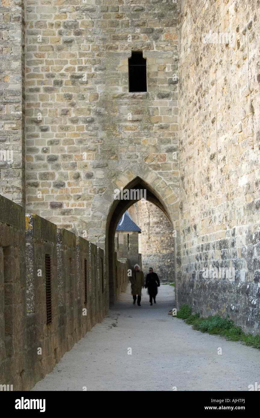 Un giovane, in silhouette, pass sotto la Tour carree de l'Eveque (Tour carrée de l'Évêque), il Cite, Carcassonne, Francia Foto Stock