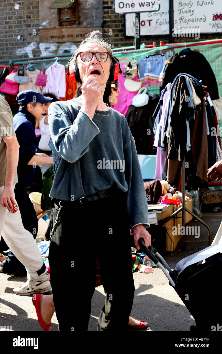 Carattere eccentrico a Londra il Brick Lane street market di indossare le cuffie di protezione Foto Stock