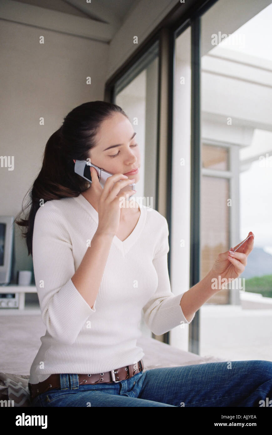 Donna utilizzando la carta di credito per telefono Foto Stock