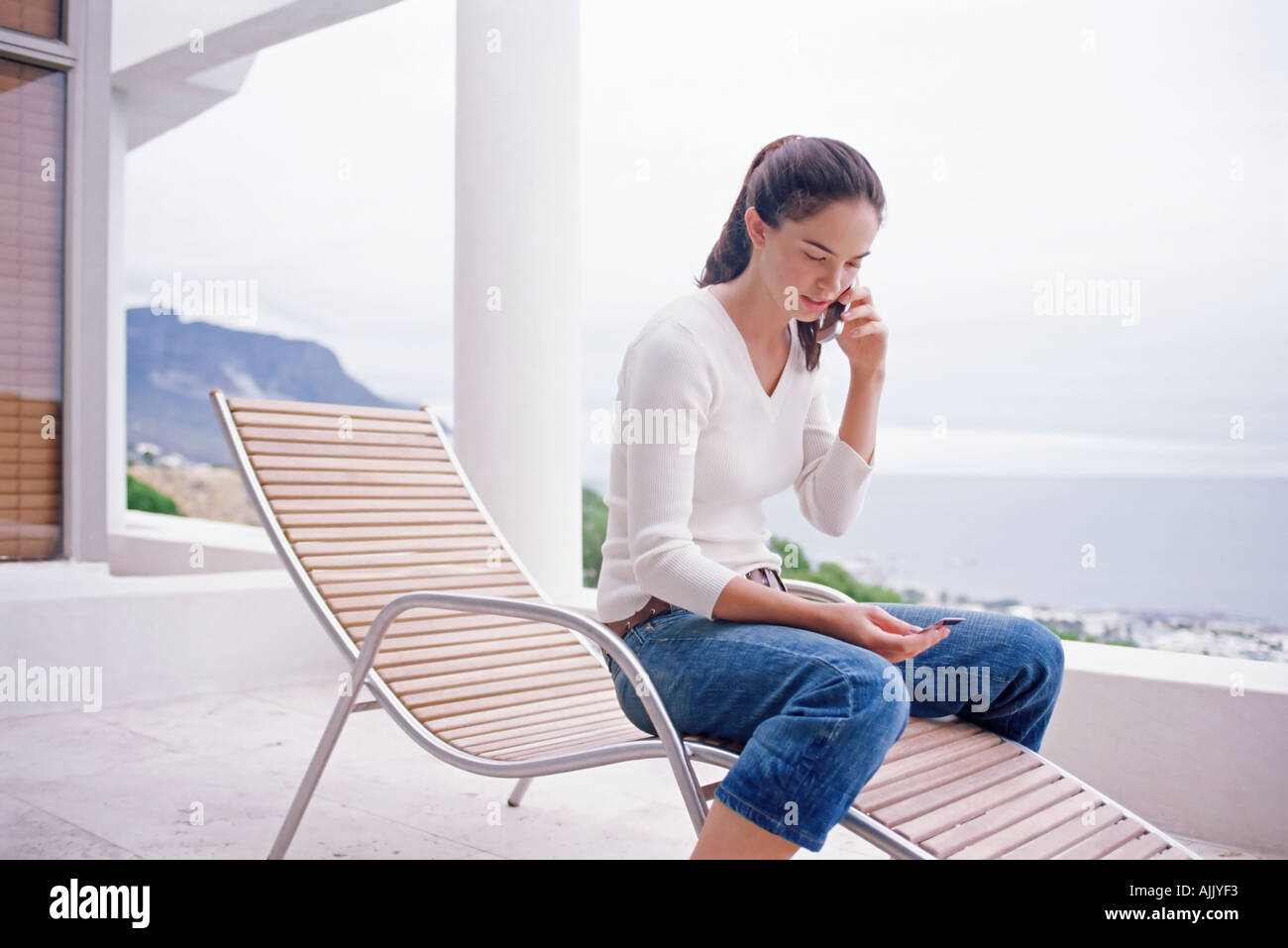Donna utilizzando la carta di credito per telefono Foto Stock