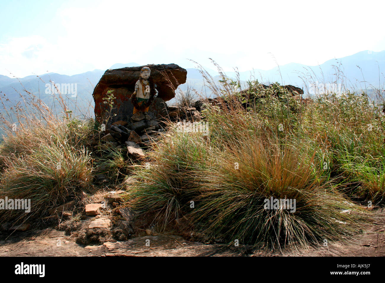 Una vecchia statua di una divinità tribali collocato accanto ad una roccia sulla cima di una collina, Marayoor, Kerala, India Foto Stock