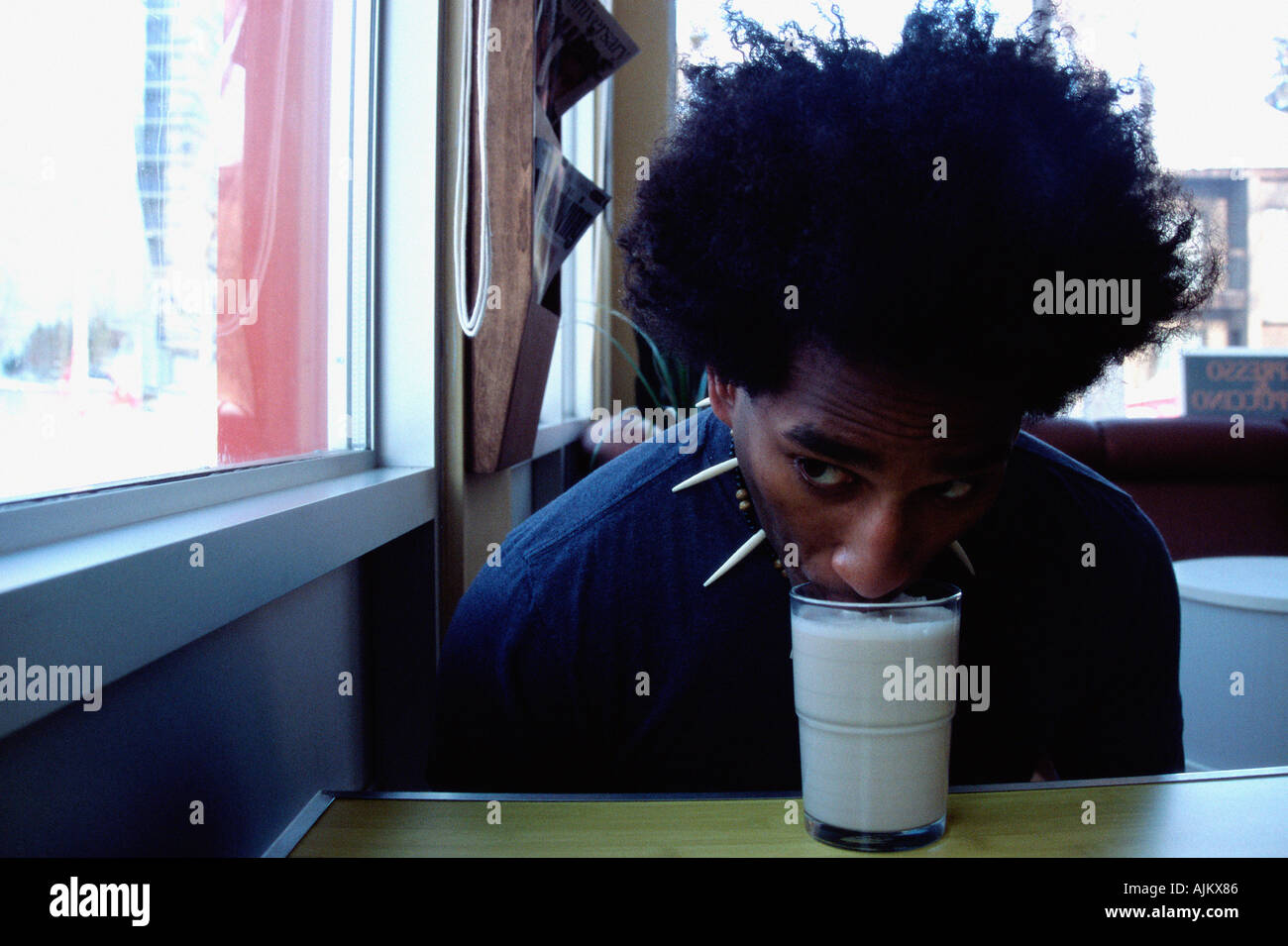 Giovane uomo beve senza mani Foto Stock