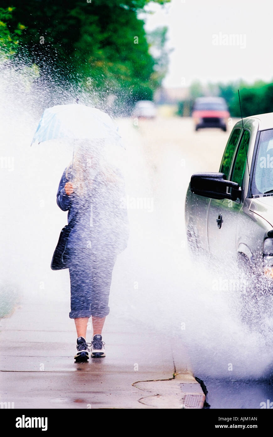 Ragazza spruzzato con acqua in auto da parte di guida Foto Stock