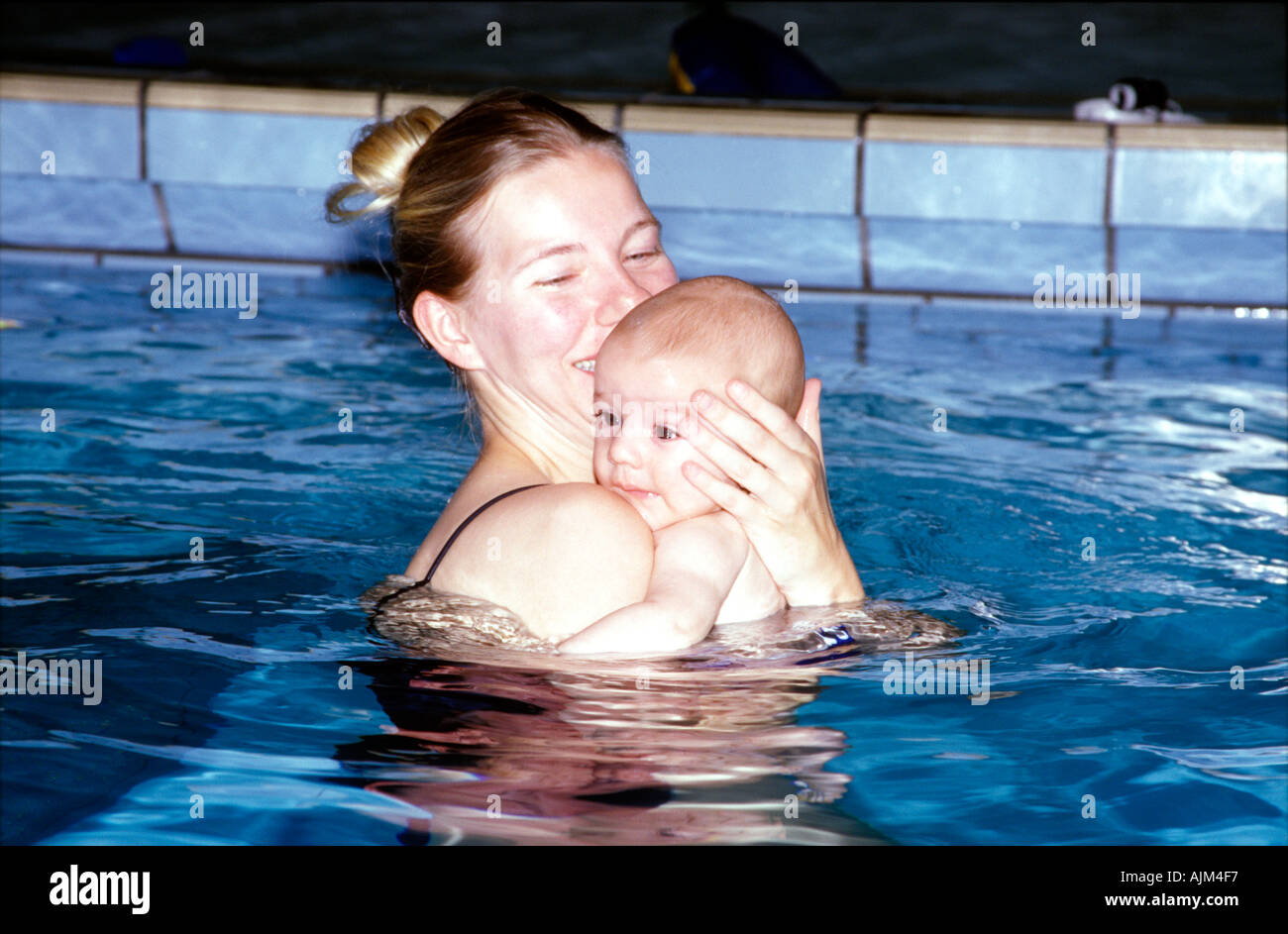 Madre con bambino in piscina per il nuoto baby Foto Stock