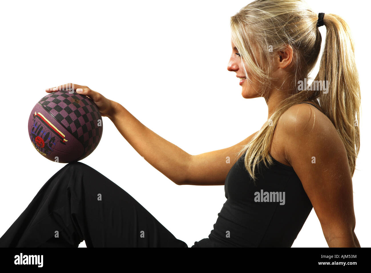 Giovane donna in nero vestito fitness con una sfera Foto Stock