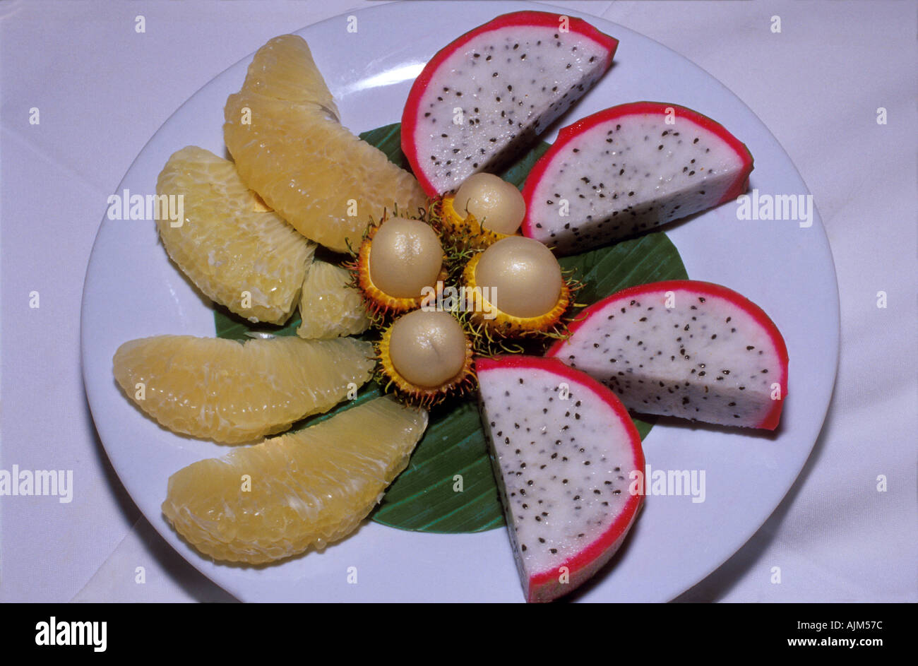 Frutti tropicali servite su un piatto in Vietnam del Sud Est Asia dragon frutto Hylocereus undatus pomelo e rambutan Nephelium Foto Stock