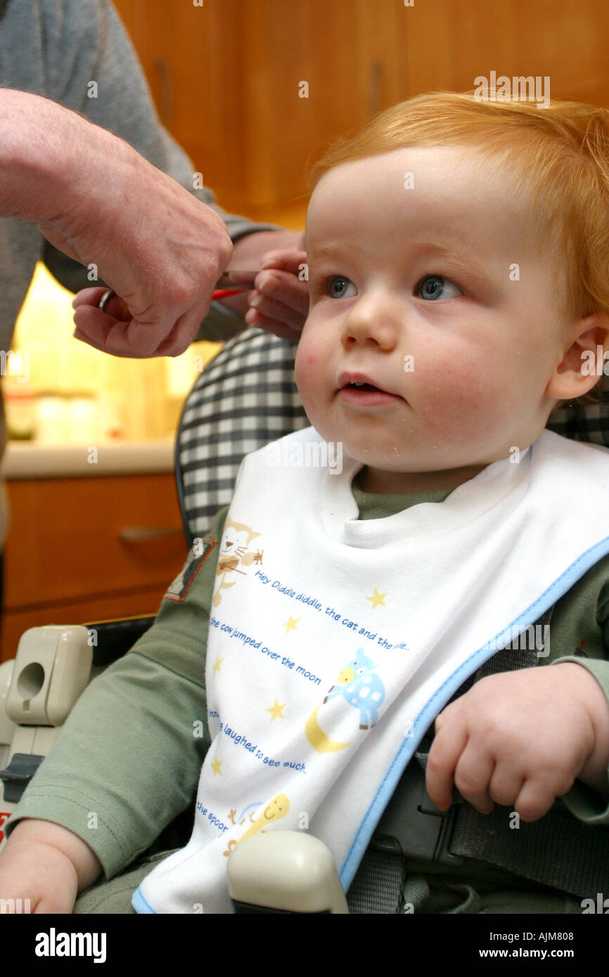 Un bambino avente il suo primo taglio di capelli di età compresa tra i 1 di  un anno di età Foto stock - Alamy