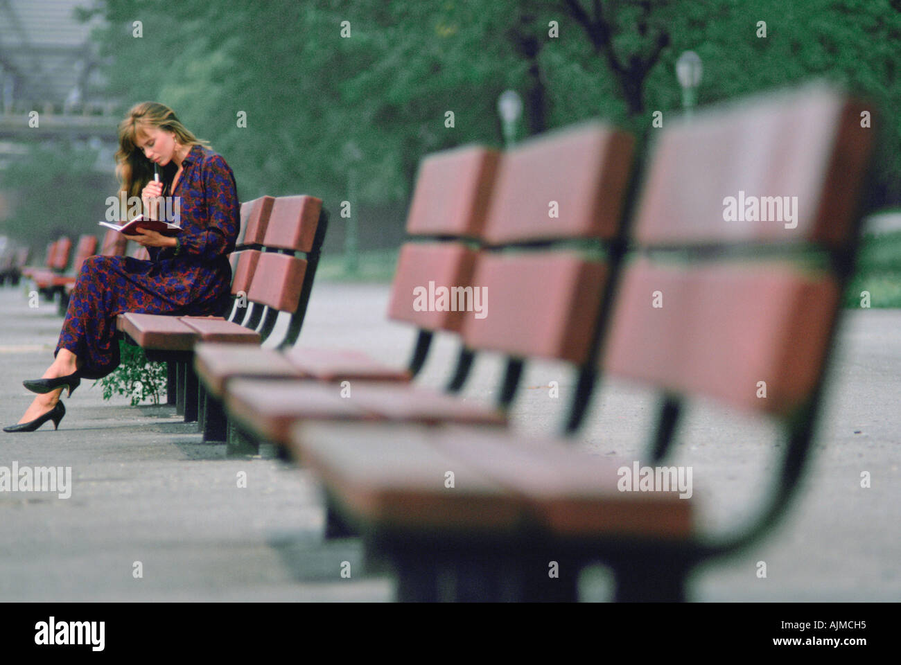 Donna su un banco di città con giorno planner Foto Stock