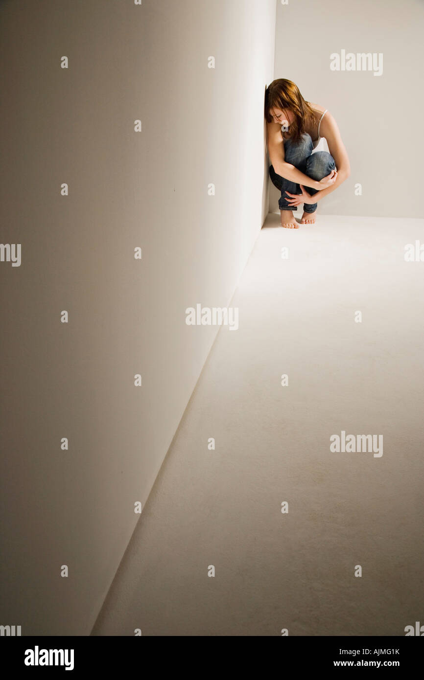 Ragazza rannicchiato in angolo Foto Stock