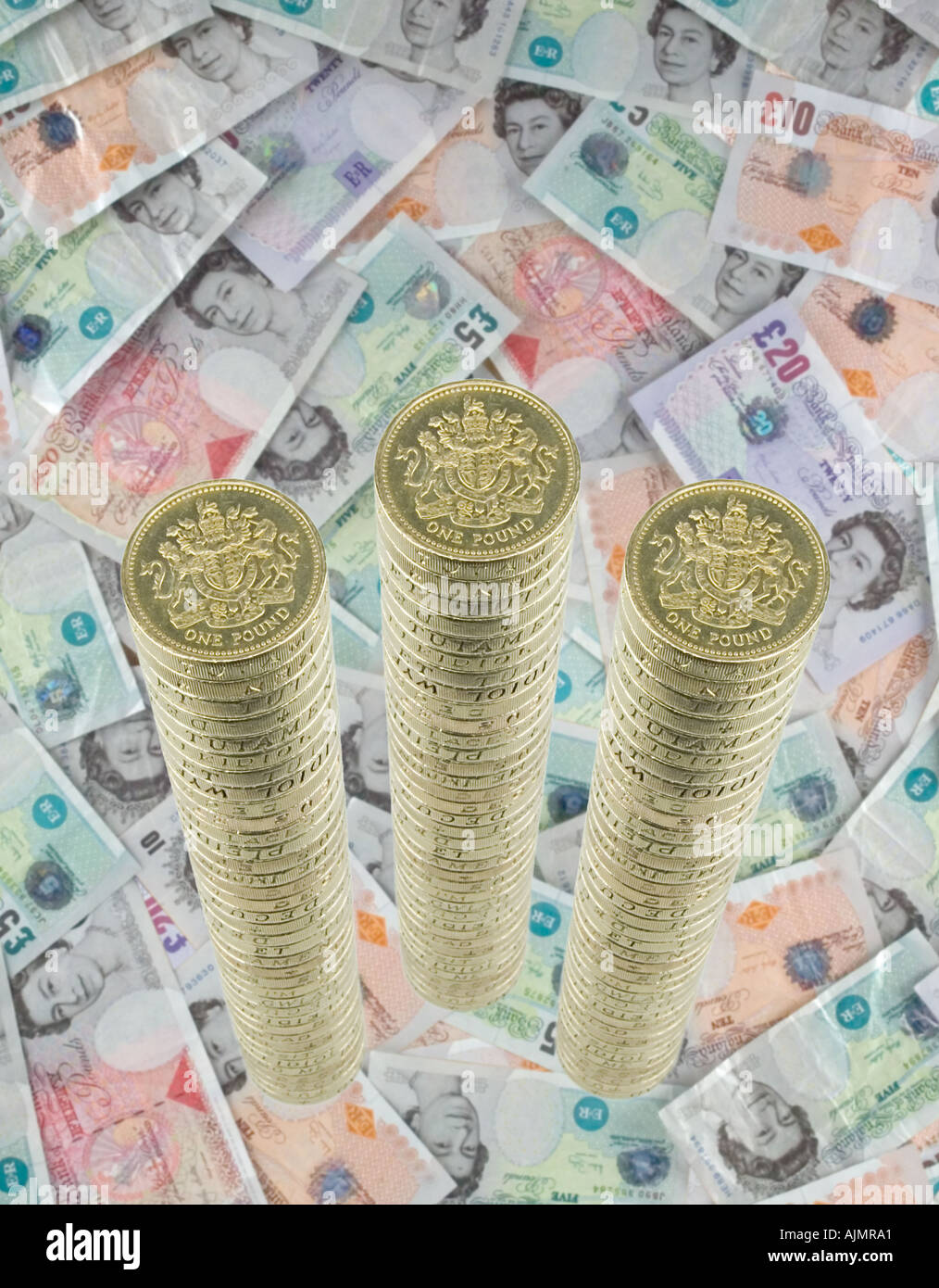 3 pile di una libbra di monete su sfondo di banconote Foto Stock