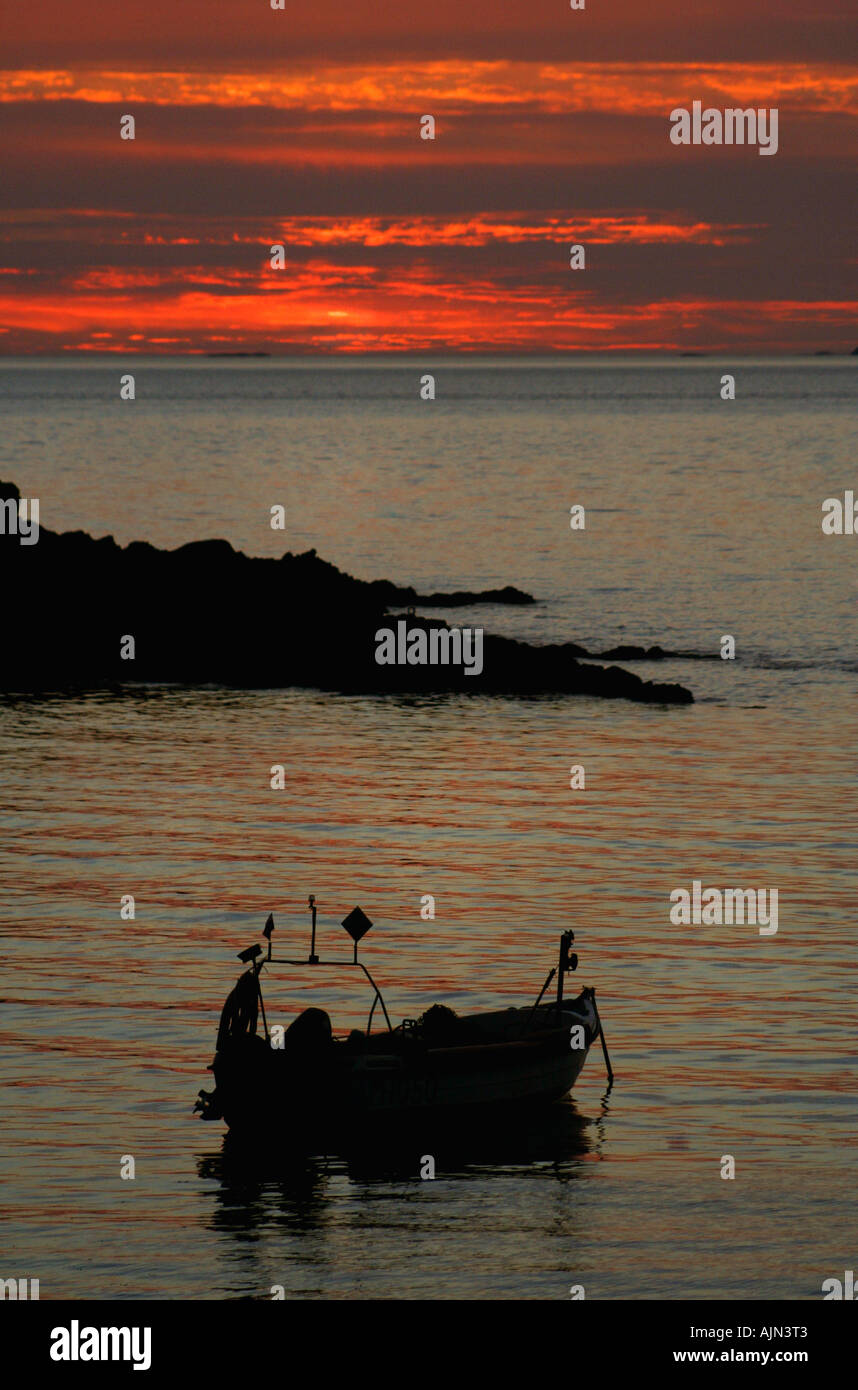 La pesca in barca al tramonto Foto Stock