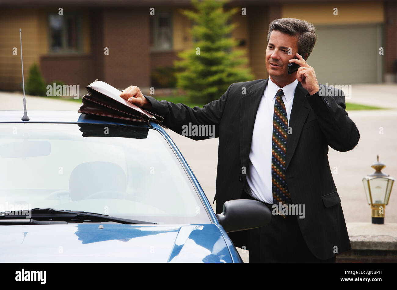 Imprenditore utilizzando il telefono cellulare in auto Foto Stock