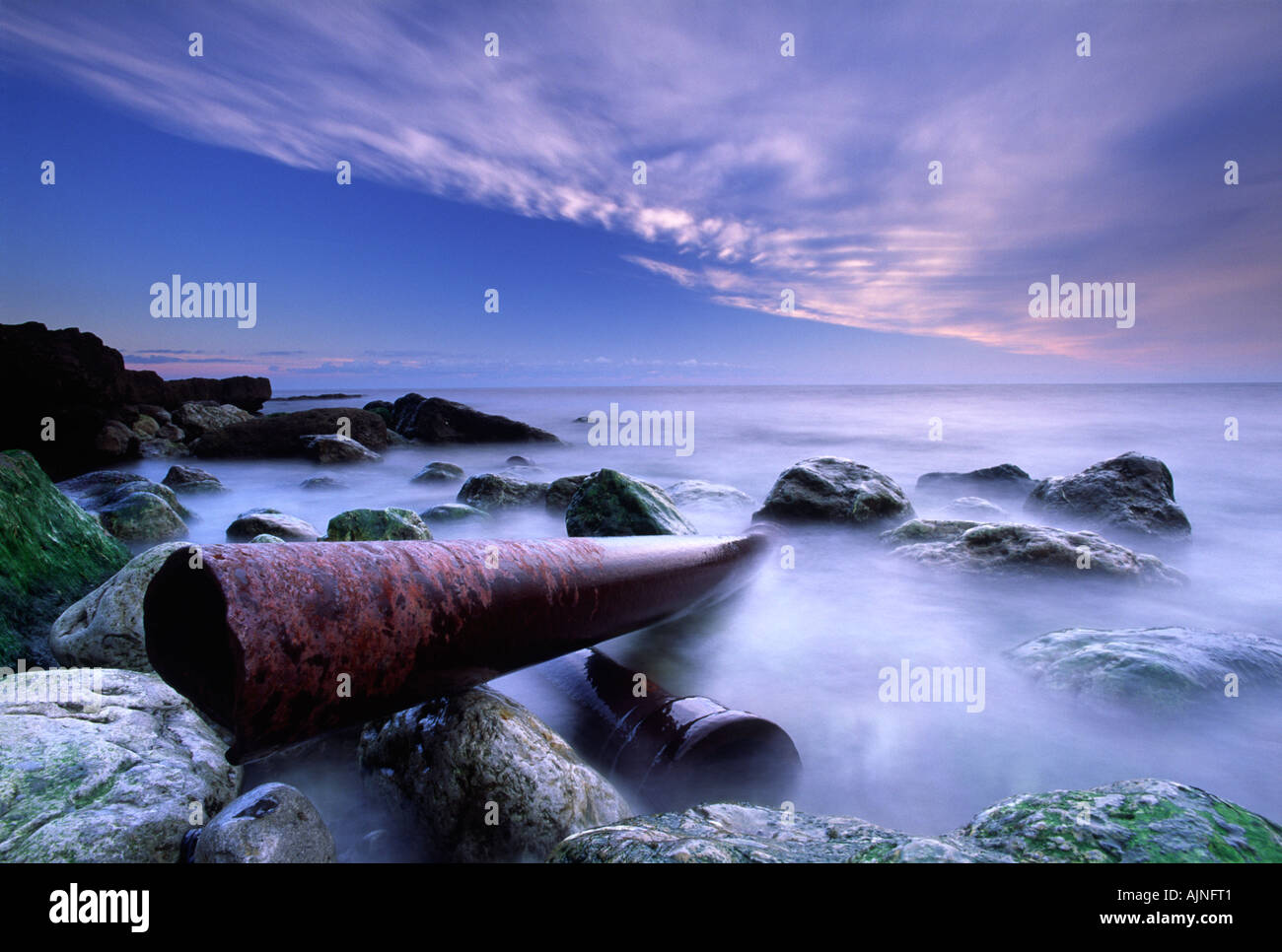 Tema ambientale di rusty tubi che portano in mare a battuta di crusca tra Ringstead Bay e Osmington nella contea di Dorset Foto Stock