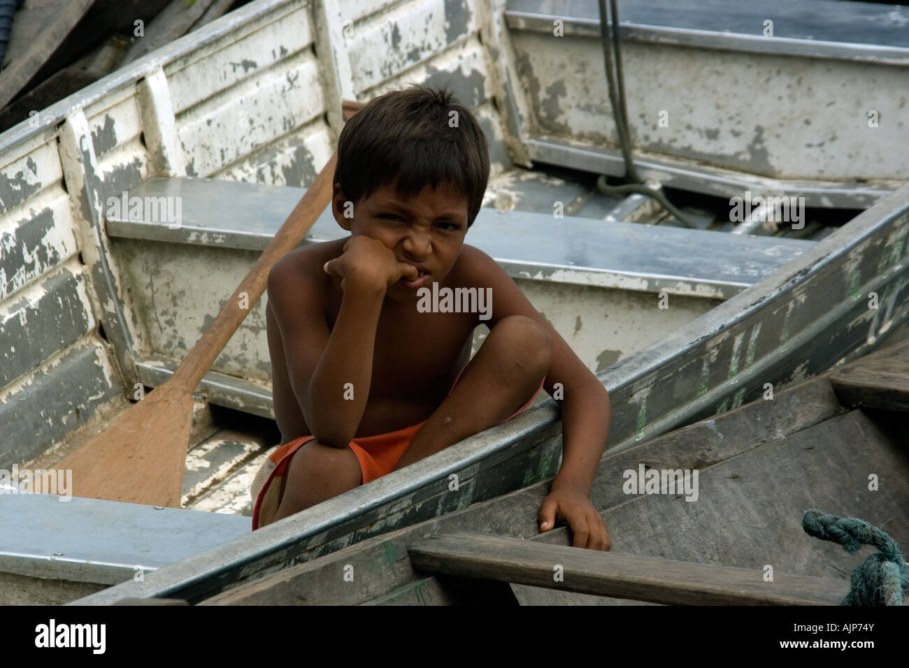 Arrabbiato ragazzo seduto in barca Tefe Amazonas Brasile Foto Stock