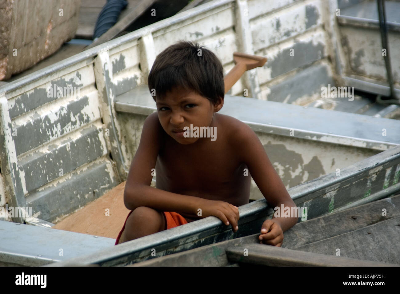 Arrabbiato ragazzo seduto in barca Tefe Amazonas Brasile Foto Stock