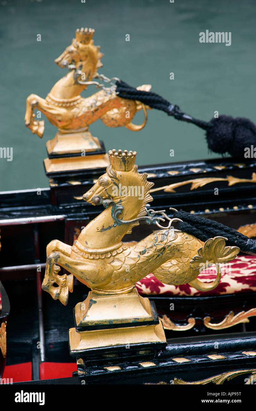 Italia Veneto Venezia ippocampo dorato cavalluccio ornamenti sui lati di una gondola ormeggiata in un canale. Foto Stock