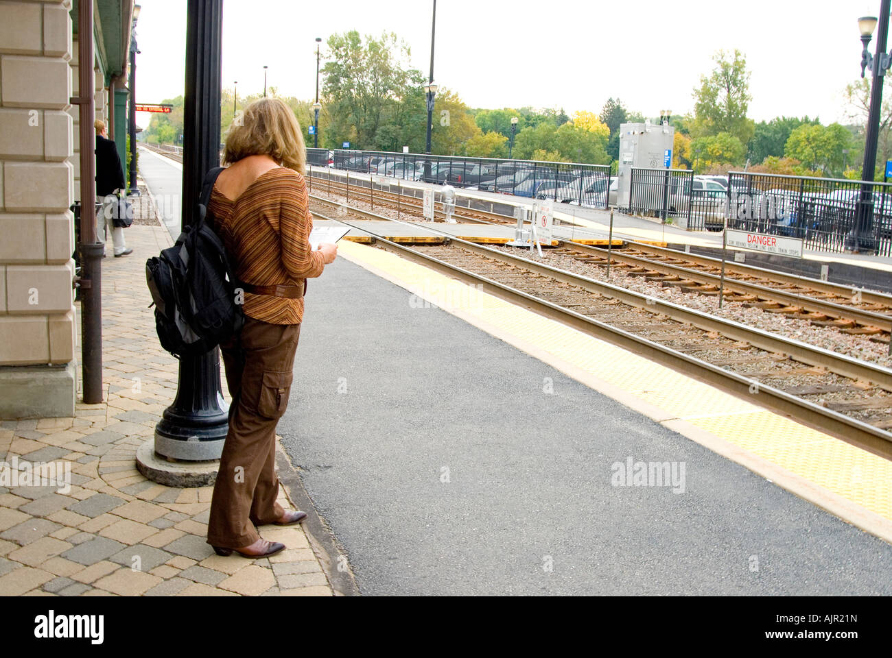 La donna in attesa sulla piattaforma del treno Foto Stock
