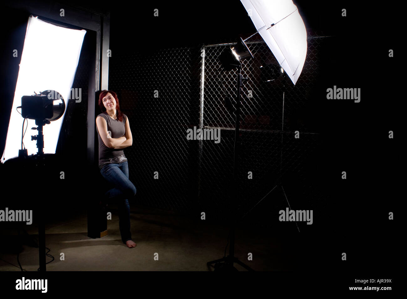 Donna in piedi nel mezzo di attrezzatura fotografica Foto Stock